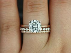 a woman's hand with a diamond ring on top of her finger and the engagement band