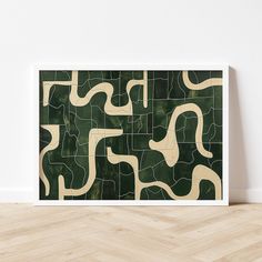 a green and white abstract art piece on a wooden floor in front of a white wall