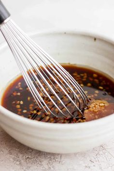 a white bowl filled with sauce and whisk