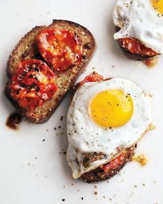 two pieces of bread with an egg on top and another piece of meat in the middle