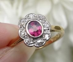 Free shipping and complementary resizing*! Exceptionally pretty and classic, this antique ruby cluster ring is as timeless as the day it was handmade with love, by an artisan, in England in the early 1900's. This gorgeous ruby is .57 carat and is surrounded by beautiful twinkling high quality diamonds that total .32 carat. The ruby varies in shade from a purple/pink/red in bright sunshine, to a cherry red at night. The diamonds add that perfect little bit of sparkle and the decorative basket is Classic Ruby Ring With Rose Cut Diamond Cluster, Vintage Red Diamond Ring With Halo Setting, Antique Ruby Ring With Rose Cut Diamonds, Antique Ruby Ring With Prong Setting, Vintage Ruby Cluster Ring With Gemstone, Victorian Ruby Cluster Ring With Gemstones, Vintage Ruby Cluster Ring With Center Stone, Vintage Ruby Ring With Prong Setting, Vintage Red Ruby Ring With Halo Setting