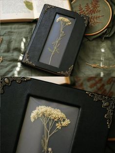 two framed pictures with flowers in them sitting on a bed next to an open book