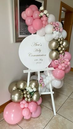 a baby announcement sign surrounded by balloons and flowers