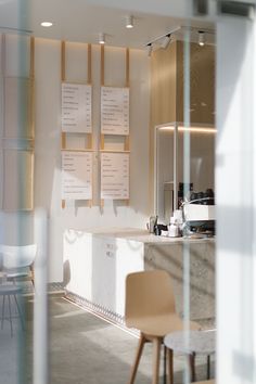 the interior of a restaurant with menus on the wall and chairs in front of it