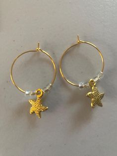 Support the preservation of sea turtles, dolphins, whales, and other marine life by purchasing these simple but beautiful, one-of-a-kind earrings crafted with hypoallergenic loops, alloy charms and West African glass beads. Fish Earrings, Star Fish, Sea Turtles, Earring Crafts, Jewelry Earrings Hoops, Marine Life, Sea Turtle, Starfish, Glass Beads