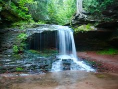 a small waterfall in the middle of a forest