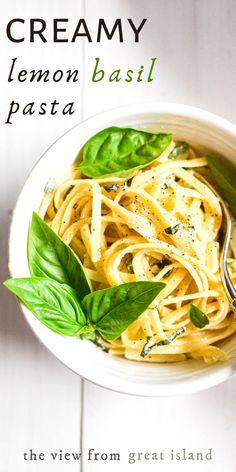 a white bowl filled with pasta and basil