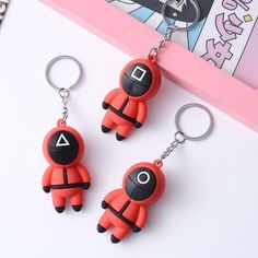 two keychains are shaped like cartoon characters