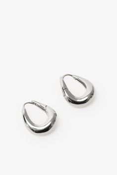 Find poetry in the everyday with our Sisley Hoops. Elegant and ever-so-chunky, these oval ornaments are crafted from sterling silver with either 18k gold or white gold plating to complement any look. Featuring a post back closure and polished finish. Each pair includes a Marcella-branded vegan leather travel case for safe storage and easy travel. | Available in one size. Approximately .5” (1.5 cm) in height, and .3" (.8 cm) in width. In silver, white gold plated sterling silver. In gold, 18KT ye Silver Oval Jewelry For Everyday, Trendy Everyday Jewelry With Polished Finish, Trendy Polished Finish Jewelry For Everyday, Everyday Teardrop Jewelry With Shiny Finish, Silver Oval Tarnish Resistant Hoop Earrings, Everyday Oval Jewelry With Shiny Finish, Silver Hoop Earrings Tarnish Resistant For Everyday Luxury, Trendy Oval Jewelry For Everyday, Oval Jewelry With Shiny Finish For Everyday