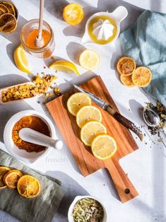 sliced lemons and other ingredients on a cutting board next to a bowl of dried herbs