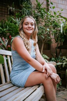 Minneapolis based senior photographer captures photos of a dreamy senior session outside for a girl wearing spring styled outfits including a white dress with sleeves, a short blue dress, and a black tshirt with white and black striped pants. #seniorgirloutfitideas #minnesotaseniorphotographer #minneapolisseniorphotographer #seniorphotoshootinspiration #seniorgirlposes #springseniorphotoshoot