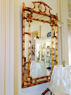 a large mirror hanging on the wall next to a lamp and other items in a room