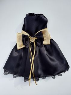 a black and gold dress with laces on the bottom, tied in a bow