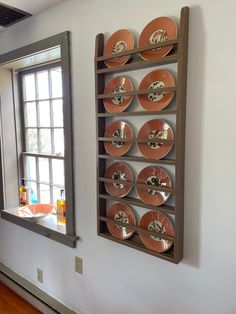 the wall is decorated with orange plates and silverware, along with an open window