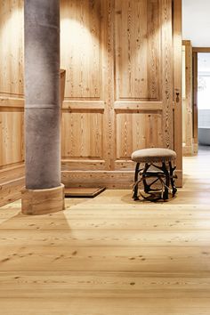 an empty room with wood paneling and a bench in the middle of the floor