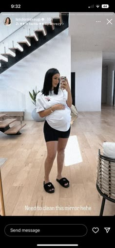 a woman taking a selfie with her cell phone while standing in the middle of a room