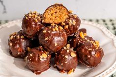 chocolate covered candies on a plate with nuts and crumbled toppings, ready to be eaten