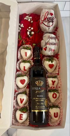 a bottle of wine and some chocolates in a box with the word love on it