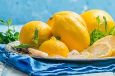 a bowl filled with lemons on top of a table