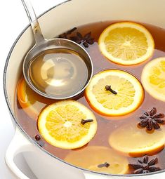 a pot filled with liquid and sliced oranges