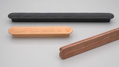 three different types of wood and black leather furniture pieces on a white surface, one with a wooden handle