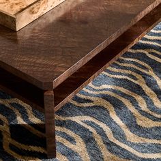 a wooden table sitting on top of a blue rug