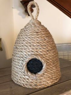 a bird house made out of jute on top of a wooden table next to stairs