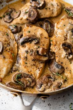 chicken with mushrooms and gravy in a skillet on a white counter top