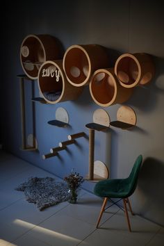 a room with several wooden objects on the wall and a green chair in front of it