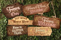 four wooden signs hanging from the side of a green wall that says families only, fautes & fliers welcome, step into a special friend follow the glitter trail