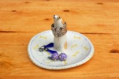 a white and blue plate with a ring on it sitting on top of a wooden table