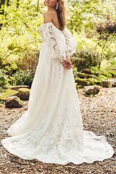 a woman in a white dress is standing on the ground and looking off into the distance