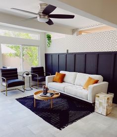 a living room filled with furniture and a ceiling fan in the middle of the room