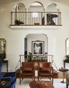 a living room filled with furniture and a painting on the wall above it's fireplace