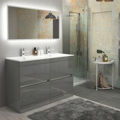 a modern bathroom with two sinks and a large mirror above the sink, along with a gray rug on the floor