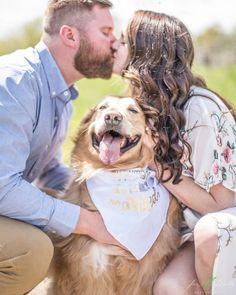 a man and woman kissing their dog on the cheek