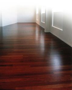 an empty room with hard wood floors and white walls