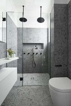 a bathroom with a toilet, sink and shower in it's center wall is shown