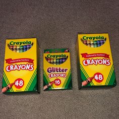 three boxes of crayons sitting on the floor