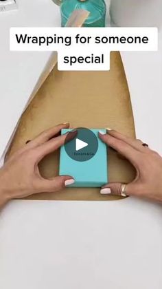 a woman holding a camera in front of a box with the words wrapping for someone special on it