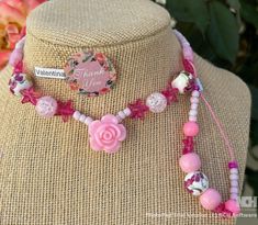 This beautiful pink beaded necklace set is perfect for adding a touch of girly glam to any outfit. The set includes a long necklace with a variety of pink beads, including pink glass beads, pink acrylic beads, and pink seed beads. A sparkling pink star charm and a delicate rose charm add a touch of whimsy to the design. The necklace is finished with a lobster clasp closure. The set also includes a shorter necklace with pink beads and a magnetic clasp closure.