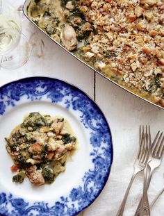 a blue and white plate topped with food next to a casserole dish