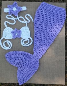 a crocheted mermaid tail, diaper and hat are laying on the ground