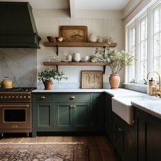 a kitchen with green cabinets and white counter tops is pictured in this image, there are shelves on the wall above the stove