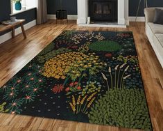 a living room with wood floors and a rug that has flowers on the floor in front of a fire place