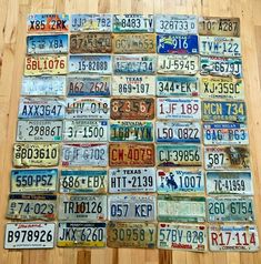 many different license plates are arranged on a wooden floor in a room with hard wood floors