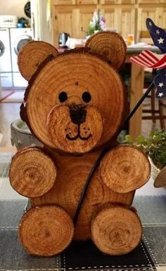 a wooden teddy bear holding an american flag