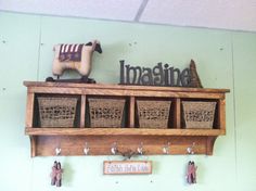 a wooden shelf with baskets and sheep figurines on it, hanging from the wall