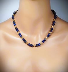 The necklace is made of 8mm blue lapis lazuli and 6mm gold lava beads.  A length is 17.25'' - 20.25'' (43cm - 50cm).  Your necklace is ready to ship. Thank you for visiting my shop. Gold Lapis Lazuli Spiritual Necklace, Royal Blue Lapis Lazuli Necklaces With Round Beads, Royal Blue Lapis Lazuli Necklace With Round Beads, Gold Lapis Lazuli Necklace With Gemstone Beads, Gold Necklaces With Lapis Lazuli Gemstone Beads, Gold Single Strand Lapis Lazuli Beaded Necklace, Gold Necklace With Lapis Lazuli Gemstone Beads, Blue Lapis Lazuli Necklace With Spacer Beads, Gemstone Choker