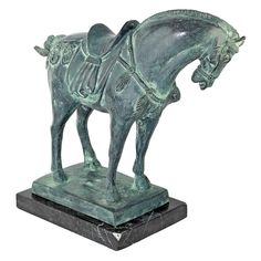 a bronze statue of a horse and rider on a black marble base against a white background